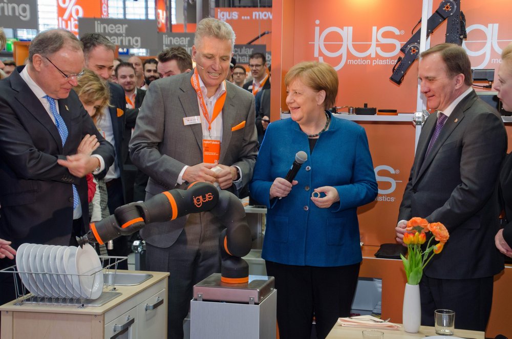 La chancelière allemande Angela Merkel découvre le bras de robot de service igus sur le HMI